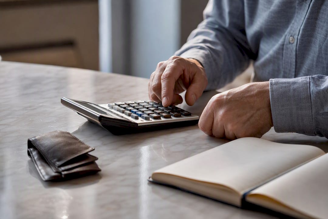 Hands using calculator on wooden table