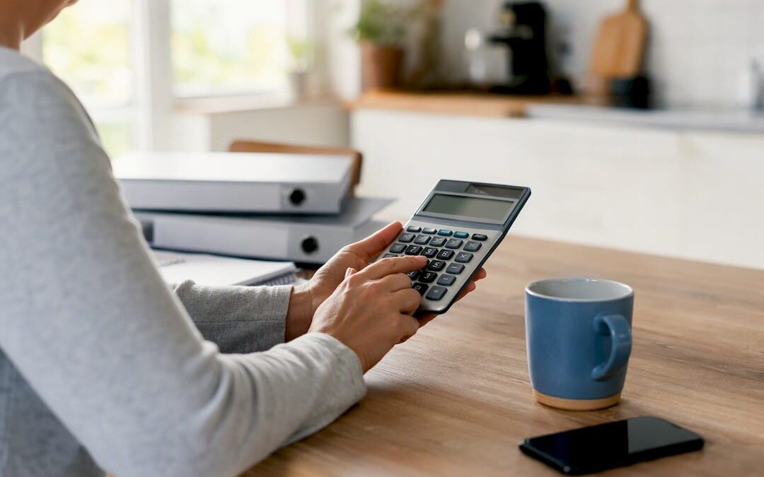 Hands using calculator on wood desk
