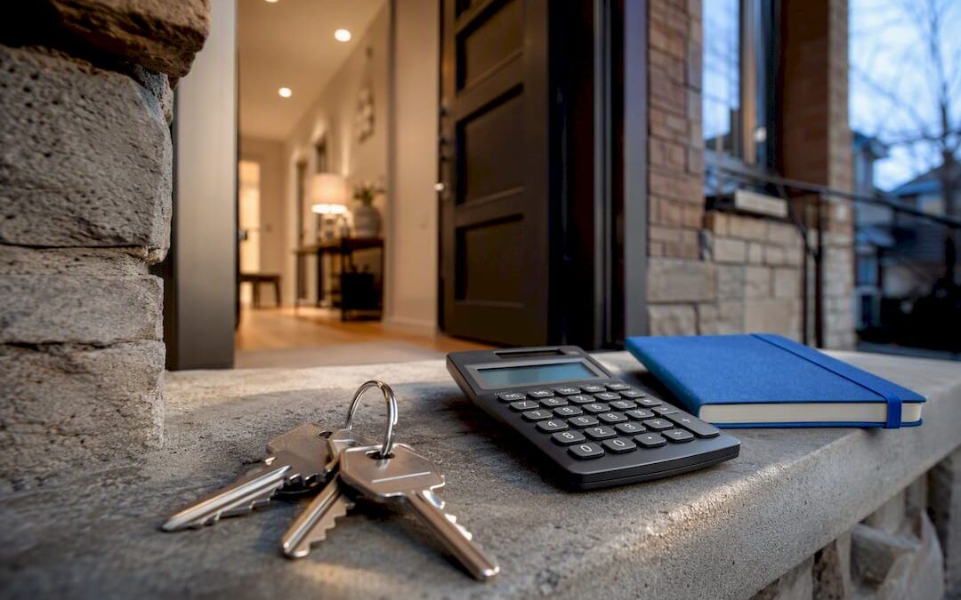 Mortgage keys and calculator beside townhouse